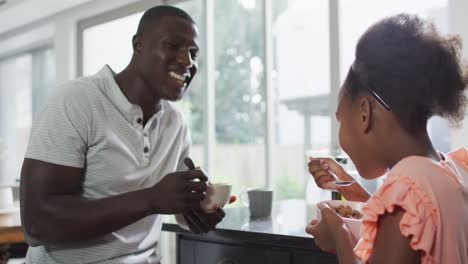 Video-of-african-american-father-and-daughter-eating-breakfast