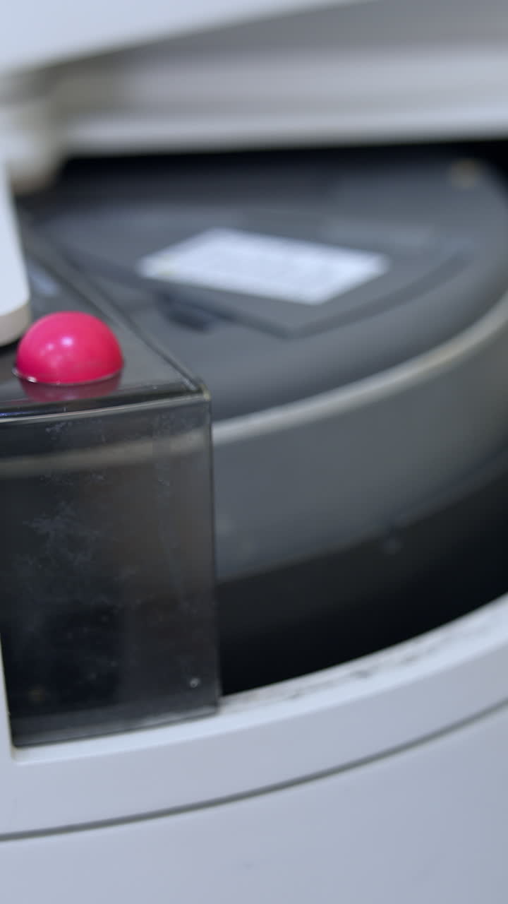 Few test tubes are moving in the apparatus. Close up. Advanced equipment in the technological science laboratory for medical tests. Vertical video
