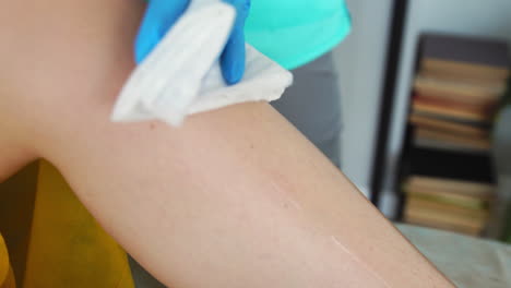 preparar los pies con crema antes de la depilación de las piernas. de cerca del maestro de shugaring prepara las piernas con aceite