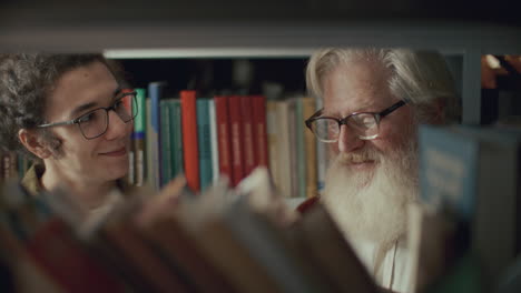 elderly librarian guiding young man in library, advising him on books to read