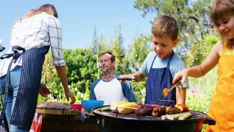 niños asando carne y verduras en la barbacoa