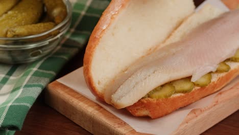 preparing a dutch herring sandwich