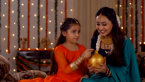 beautiful mother teaching her cute daughter the concept of money saving - parenting and financial