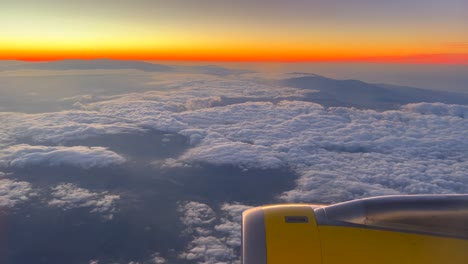 avión motor a reacción de turbina volando sobre las nubes con puesta de sol naranja amanecer horizonte, avión por encima de las nubes, vacaciones viajes de vacaciones, tiro de 4k