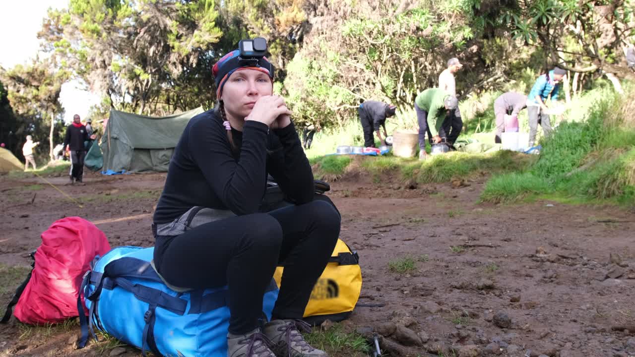 viajera con cámaras de acción en la cabeza se sienta en bolsas y espera a un equipo