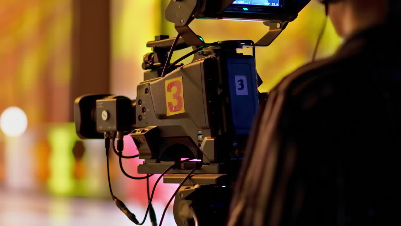 Man filming with professional camera on the backstage of a TV set