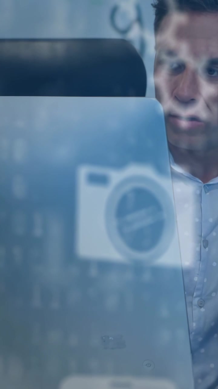 Vertical video: Tech man shifting by frost panel, camera icon flickering causing collar tugging