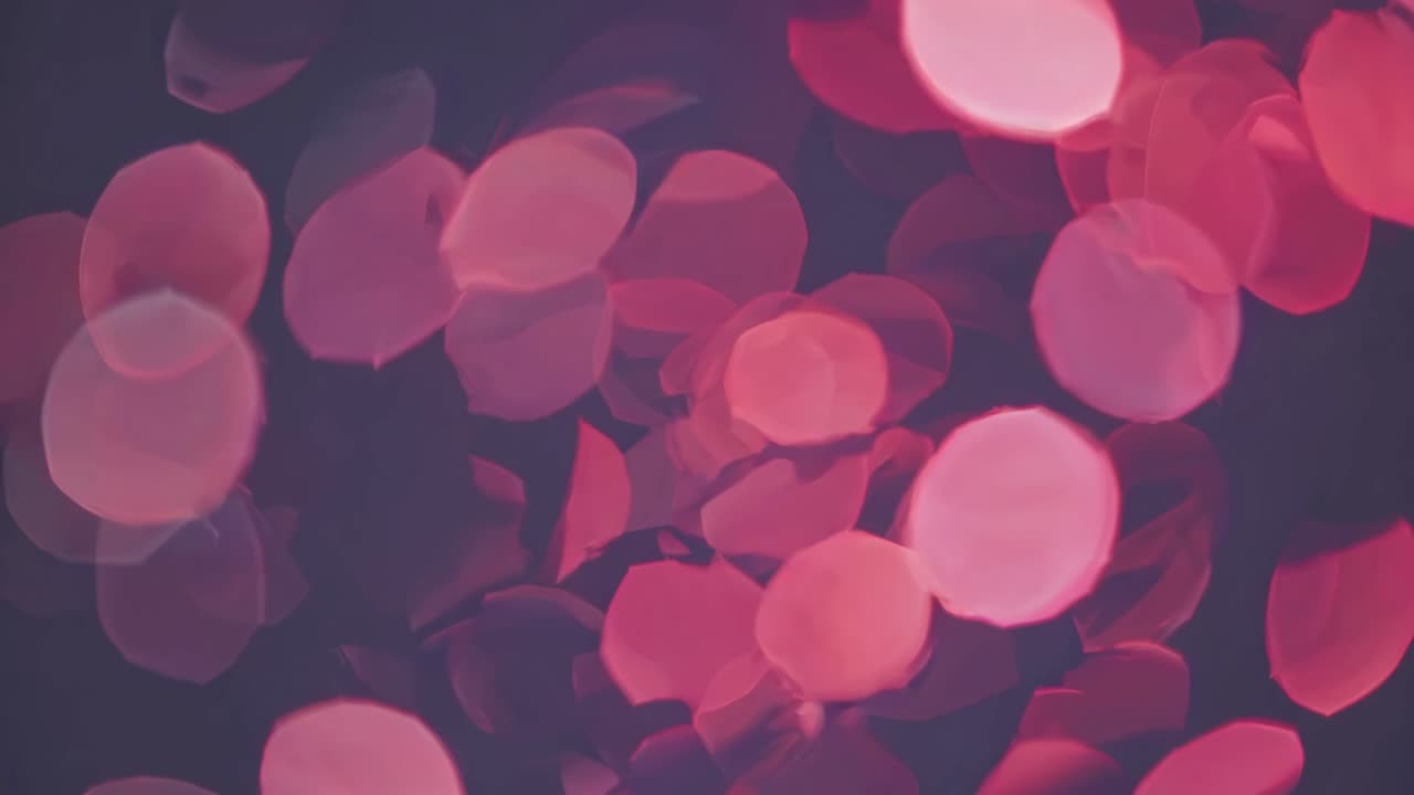 Abstract video with a bokeh effect, showcasing soft pink and red circular lights