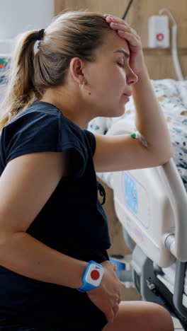 caucasian pregnant lady sits on the fit ball in hospital ward. woman has painful contractions and tries slow breathing. vertical video