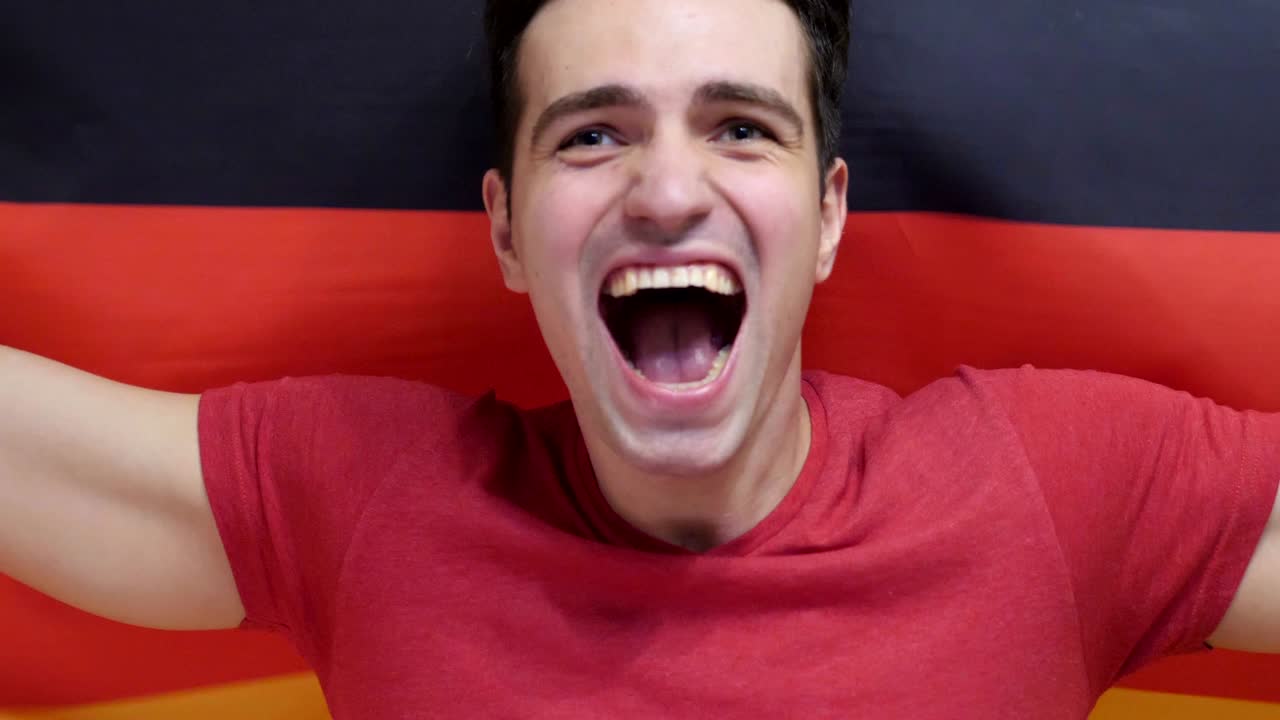 독일의 젊은이가 독일의 발을 느린 동작으로 들고 축하합니다.