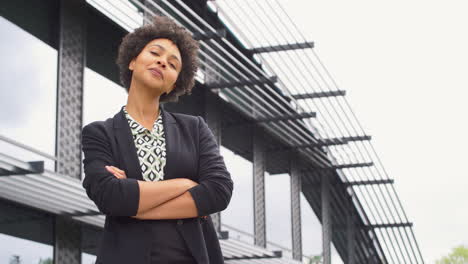 retrato de una mujer de negocios sonriente de pie fuera de un moderno edificio de oficinas