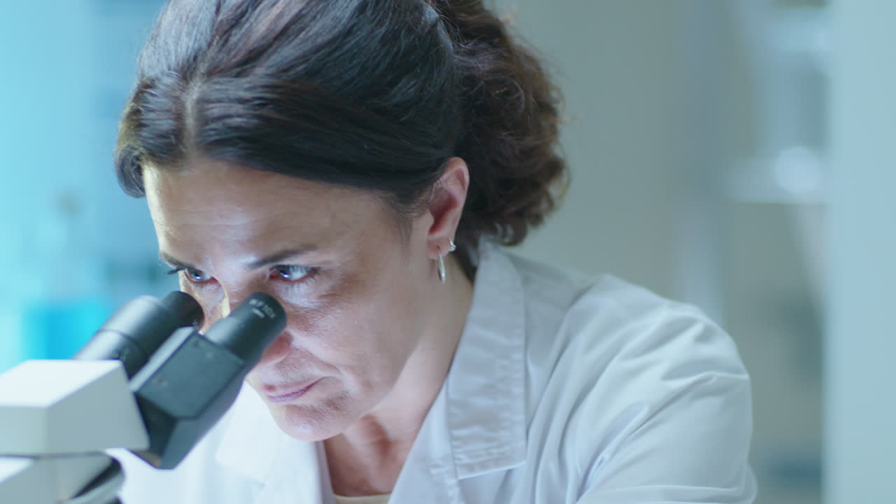 científico usando el microscopio en un laboratorio