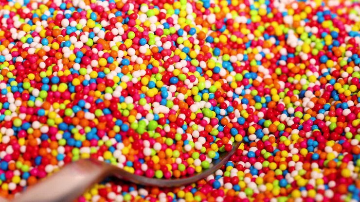 Spoon gathers vibrant sprinkles in close-up view