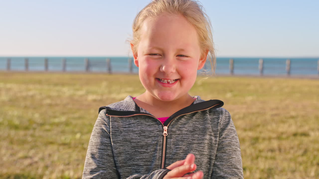 Libertà, giocoso e viso di un bambino in spiaggia