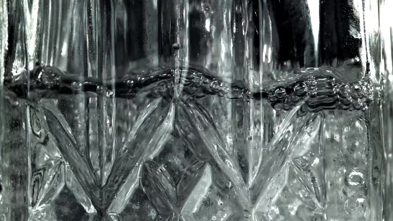 Klart vann fyller et mønstret glass – nærbilde