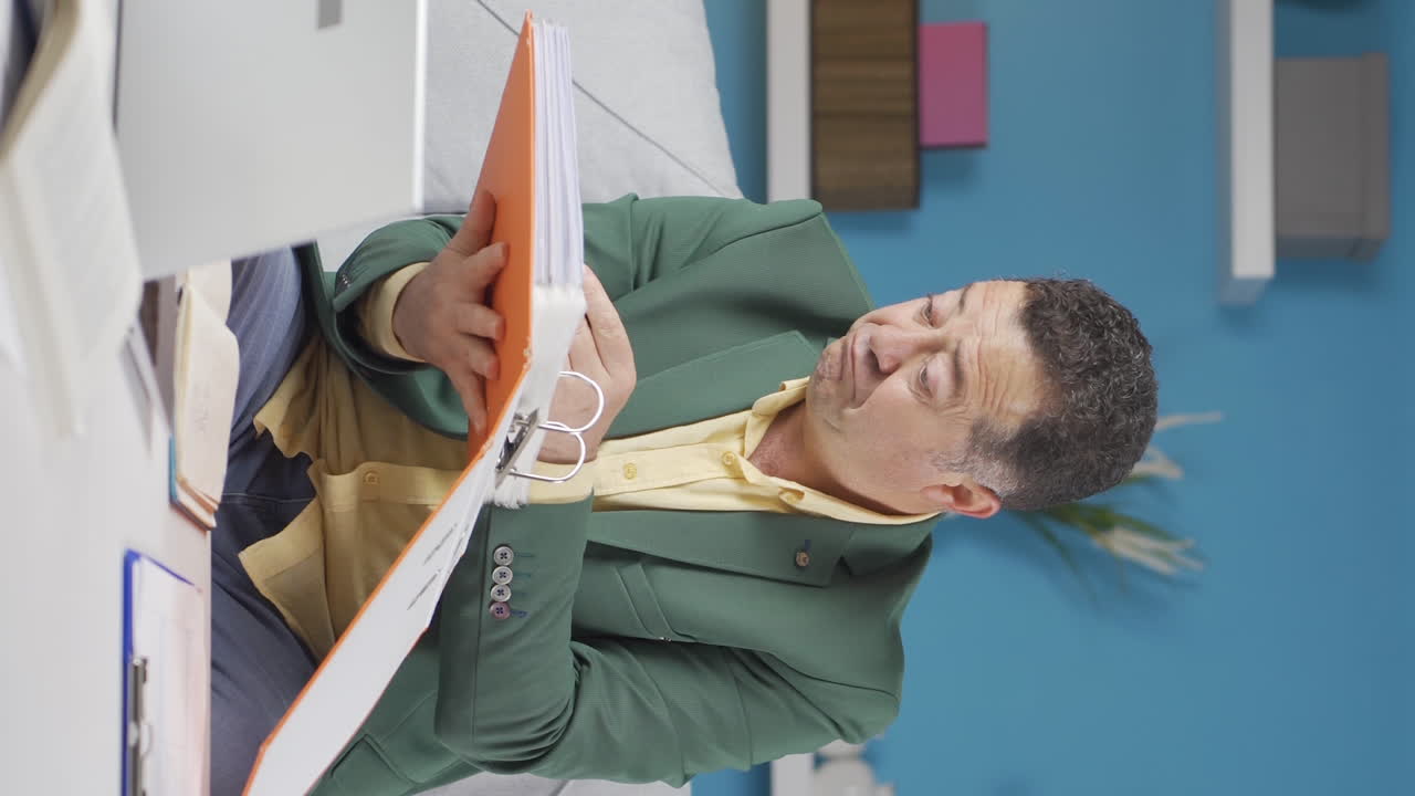 홈 오피스 직원 노인이 서류 파일을 검토하는 수직 비디오.