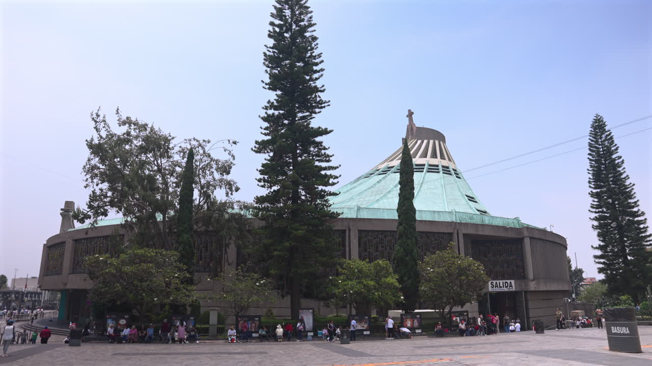 Tourists at the New or modern Basilica of Our Lady of Guadalupe site in Mexico City - tilt down reveal