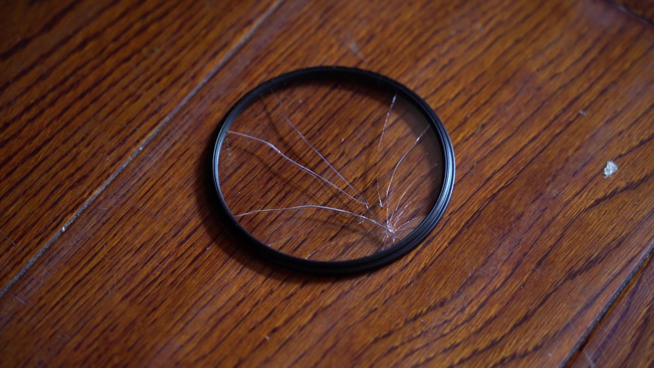 Handheld Shot of a cracked Camera Lens Filter on the ground
