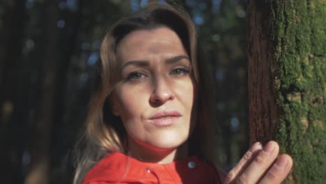 mujer atractiva conectándose con la naturaleza mirando a la cámara