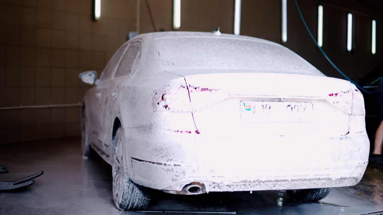 A car being covered in foam at a self service car wash