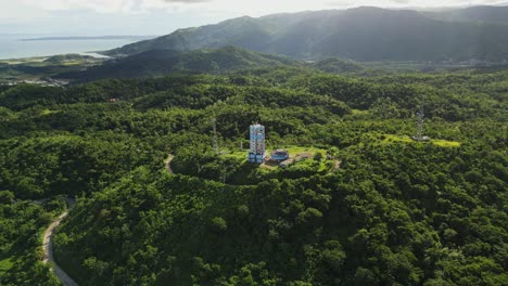 aerial orbit of pagasa weather doppler radar station atop lush tropical island hills during daytime at buenavista, catanduanes, philippines
