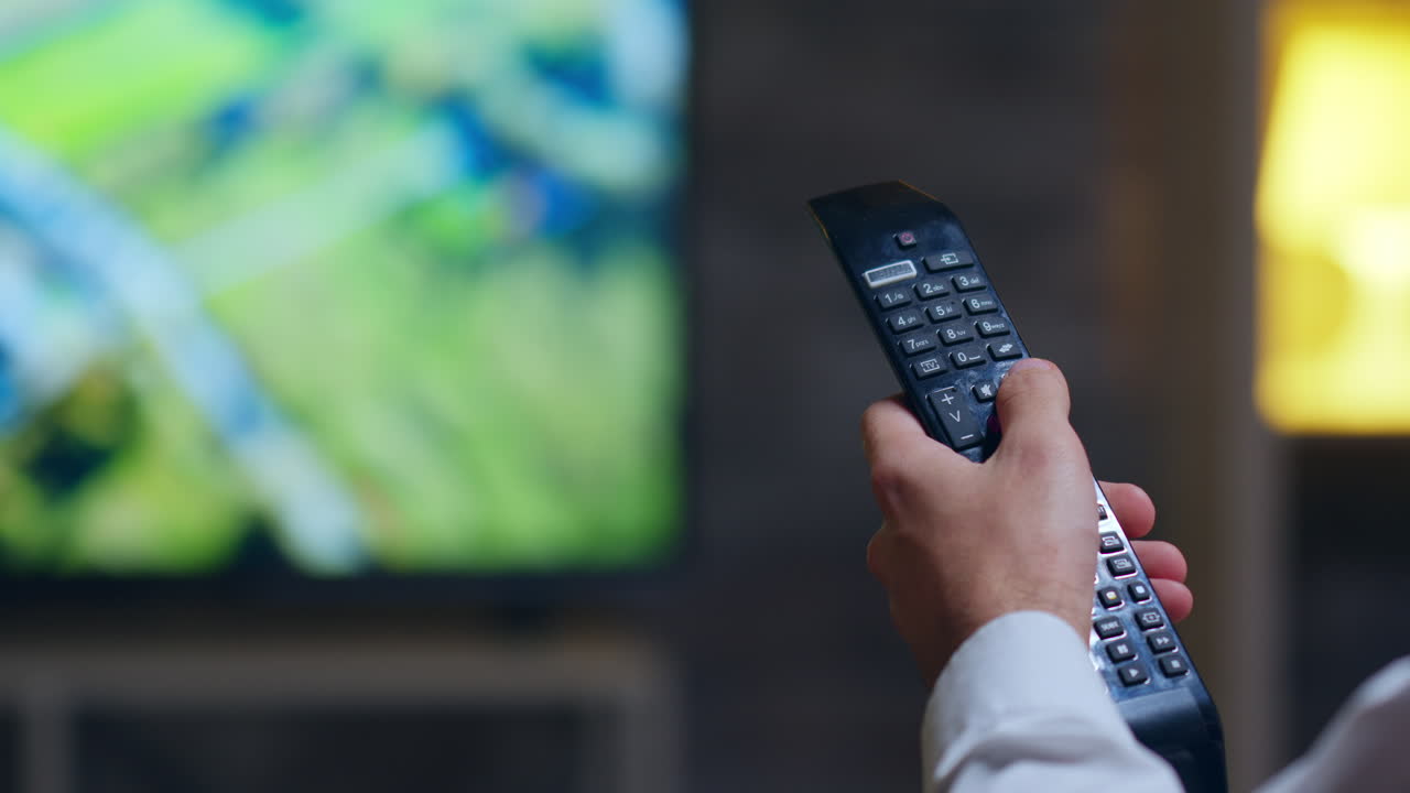 Back view of entrepreneur switching tv programs