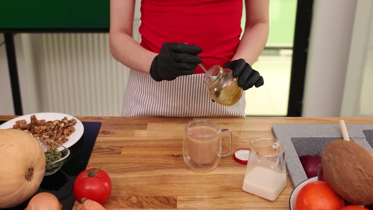 Preparing a healthy drink with honey, nuts, seeds, tea, milk, and fruits