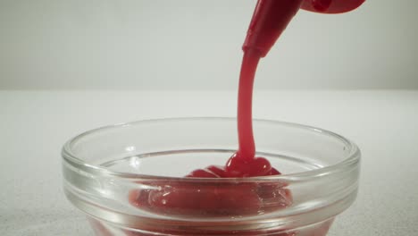 ketchup pouring into a bowl