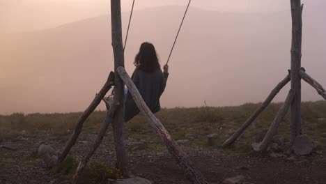 mujer columpiándose en un columpio en lousa baloico al atardecer, portugal