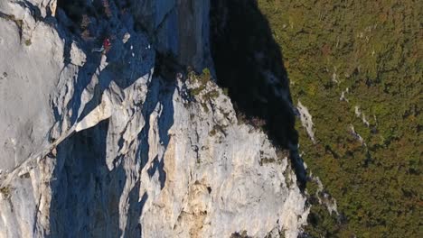 aerial shot of a man base jumping in slow motion from a cliff in choranche