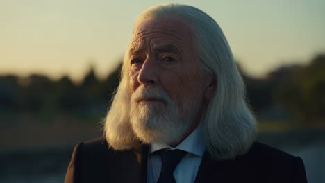 portrait of an elderly man with long white hair and a beard