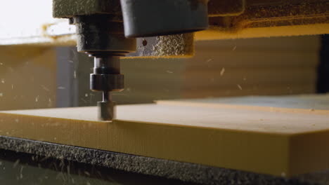 automated cnc router precisely carving into yellow foam, with particles flying off