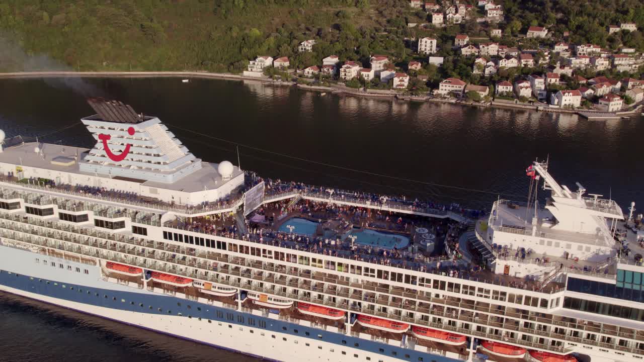 Vista aerea di una nave da crociera che naviga nella Baia di Kotor al tramonto a Tivat, Montenegro, con illuminazione mozzafiato del tramonto, atmosfera calma e riprese drone di alta qualità che esaltano la bellezza naturale