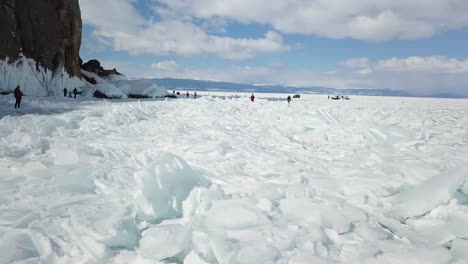 people walking on cracked ice on lake baikal in winter