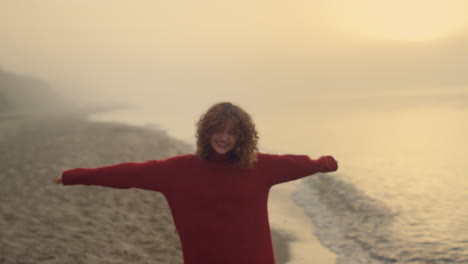 cheerful girl enjoying leisure time on beach. happy woman walking along seaside