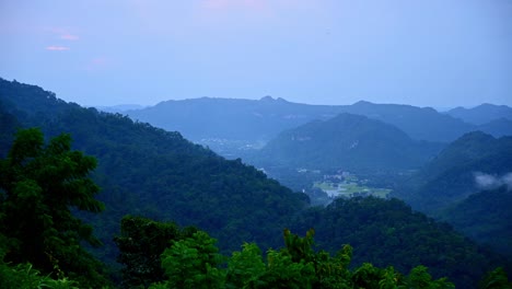 Lapso-De-Tiempo-Del-Paisaje-Desde-Un-Mirador-En-El-Parque-Nacional-Khao-Yai-Cubierto-De-Nubes-De-La-Tarde-Y-Luego-Revelando-Pueblos-En-El-Valle-Abajo-Hasta-Que-Oscureció