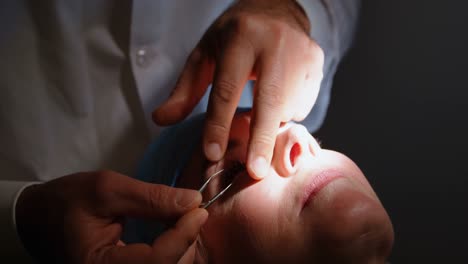 optometrist examining patient eyes with eye test equipment in clinic 4k