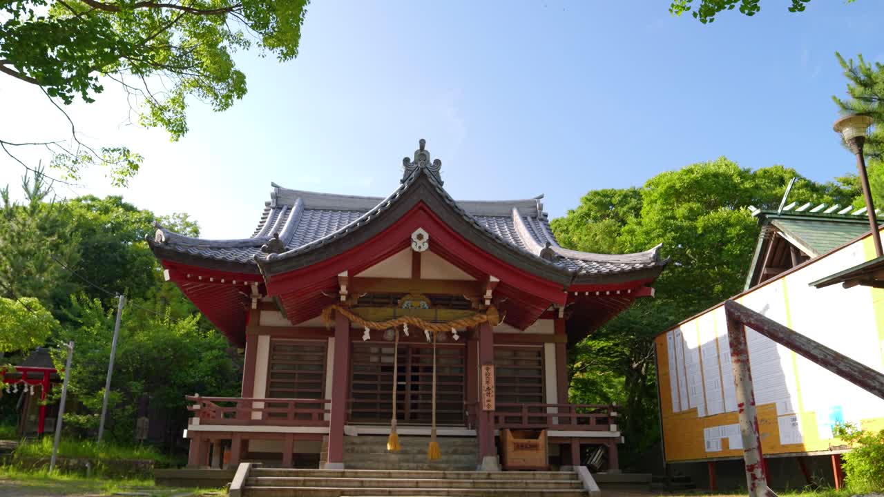 Traditional Japanese Shrine with Stone Steps and Green Trees