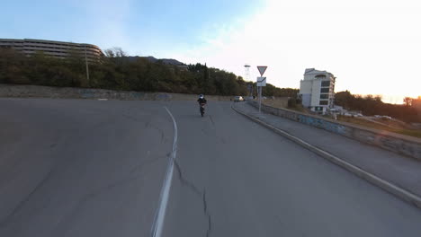 Exciting-action-shot-of-a-stunt-rider-doing-a-wheelie-on-a-motorcycle-in-the-streets-at-sunset