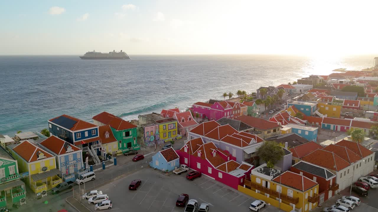 Varm solnedgangsutsikt fra drone av Pietermaai-arkitektur ved vannkanten med fargerike fasader i Willemstad.