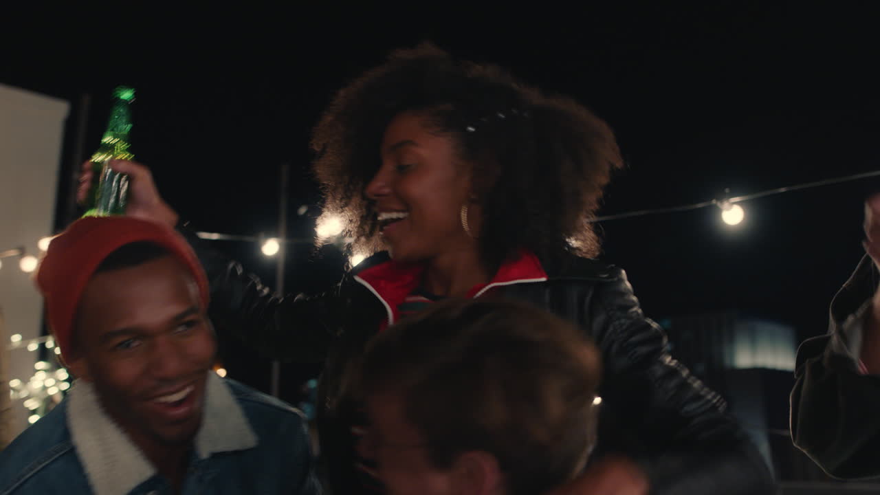 grupo de amigos jóvenes divirtiéndose bailando juguetón juntos disfrutando de la fiesta en la azotea por la noche riendo celebrando la amistad