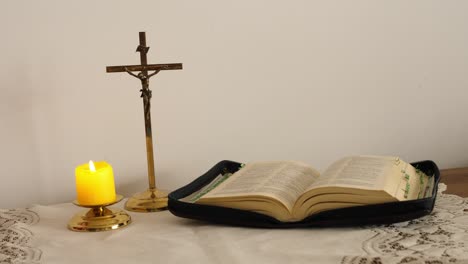 the faithful light a candle before prayer, the bible and cross