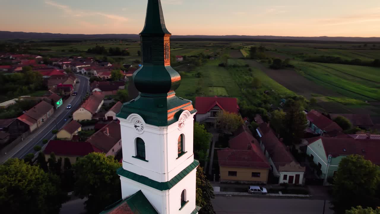 vista de la órbita aérea de la torre del reloj de la iglesia protestante reformada al atardecer