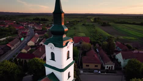 Aerial-orbit-view-of-reformed-protestant-church-clock-tower-at-sunset
