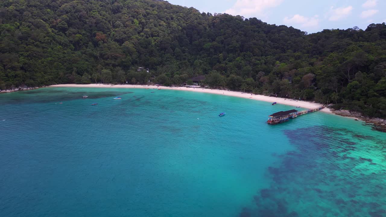 turquoise water, lagoon Beach on Besar Perhentian island with a lush tropical forest in the background