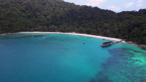 turquoise-water,-lagoon-Beach-on-Besar-Perhentian-island-with-a-lush-tropical-forest-in-the-background