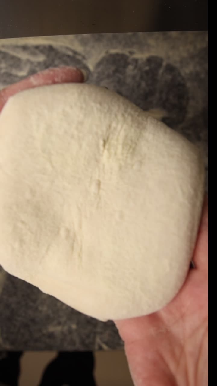 Hands Dusting Fresh Dough with Flour for Baking
