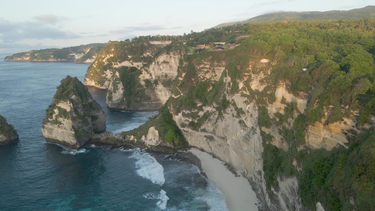 Filmische Drohnenaufnahme der ikonischen Kalksteinklippen des Diamond Beach und des türkisfarbenen Ozeans auf Nusa Penida, Bali. Geeignet für Reisedokumentationen und Wellness-Retreats