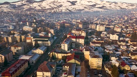 vista aérea de una ciudad de invierno con montañas cubiertas de nieve en el fondo