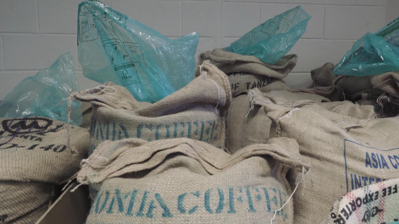 Coffee bean bags lying around on a warehouse, slow trucking shot